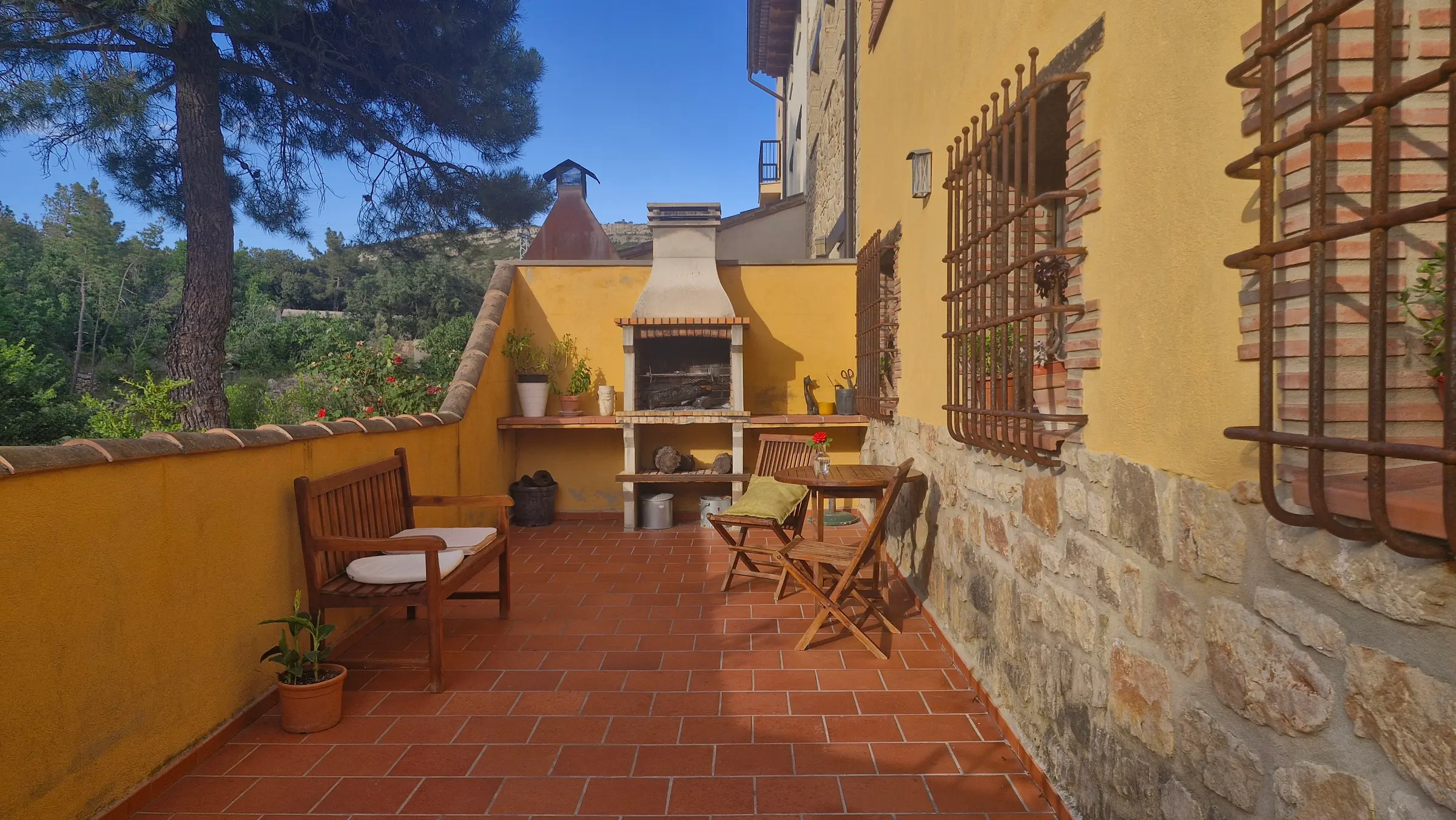 Terraza de La Canterica con barbacoa de obra y banco de madera