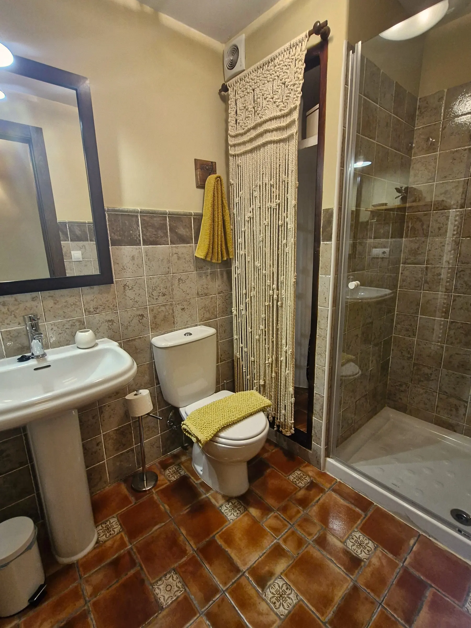 Baño de El Jardín con plato de ducha, cortina de macramé y lavabo con pie
