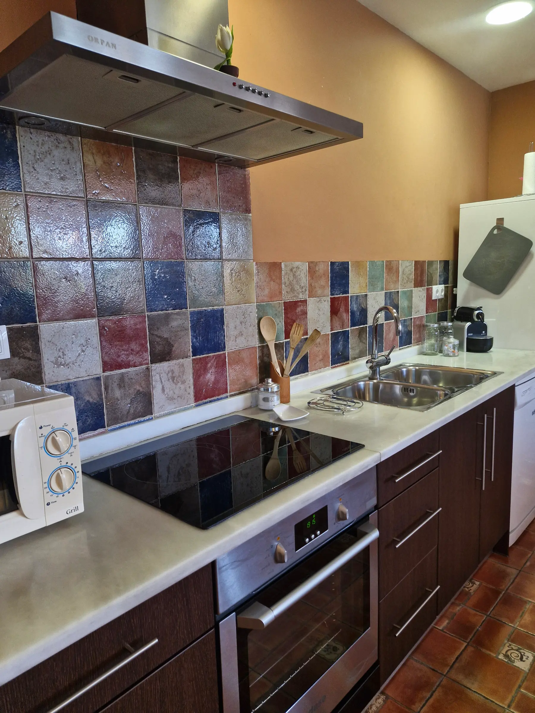 Cocina equipada de El Jardín con placa, horno y frontal de azulejo de colores