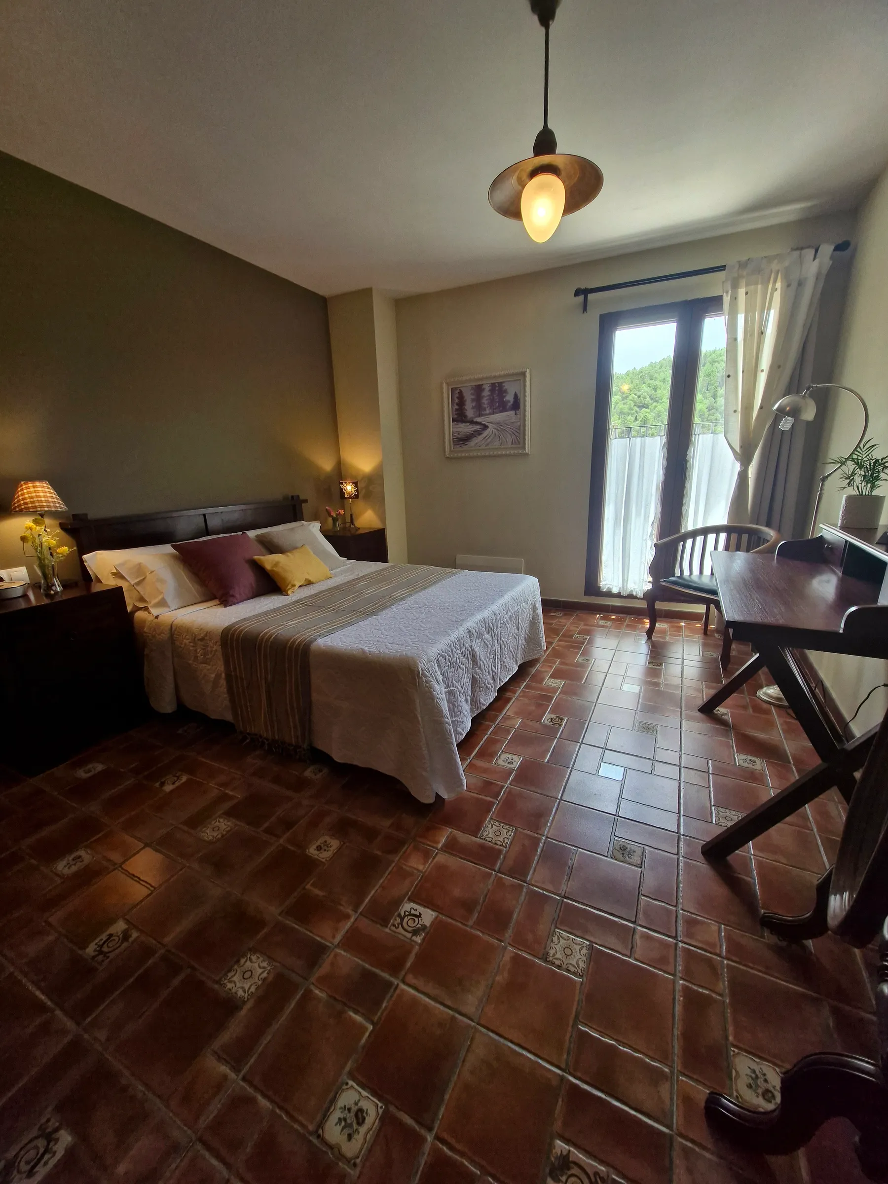 Dormitorio de matrimonio de El Mirador con suelo de barro y ventana