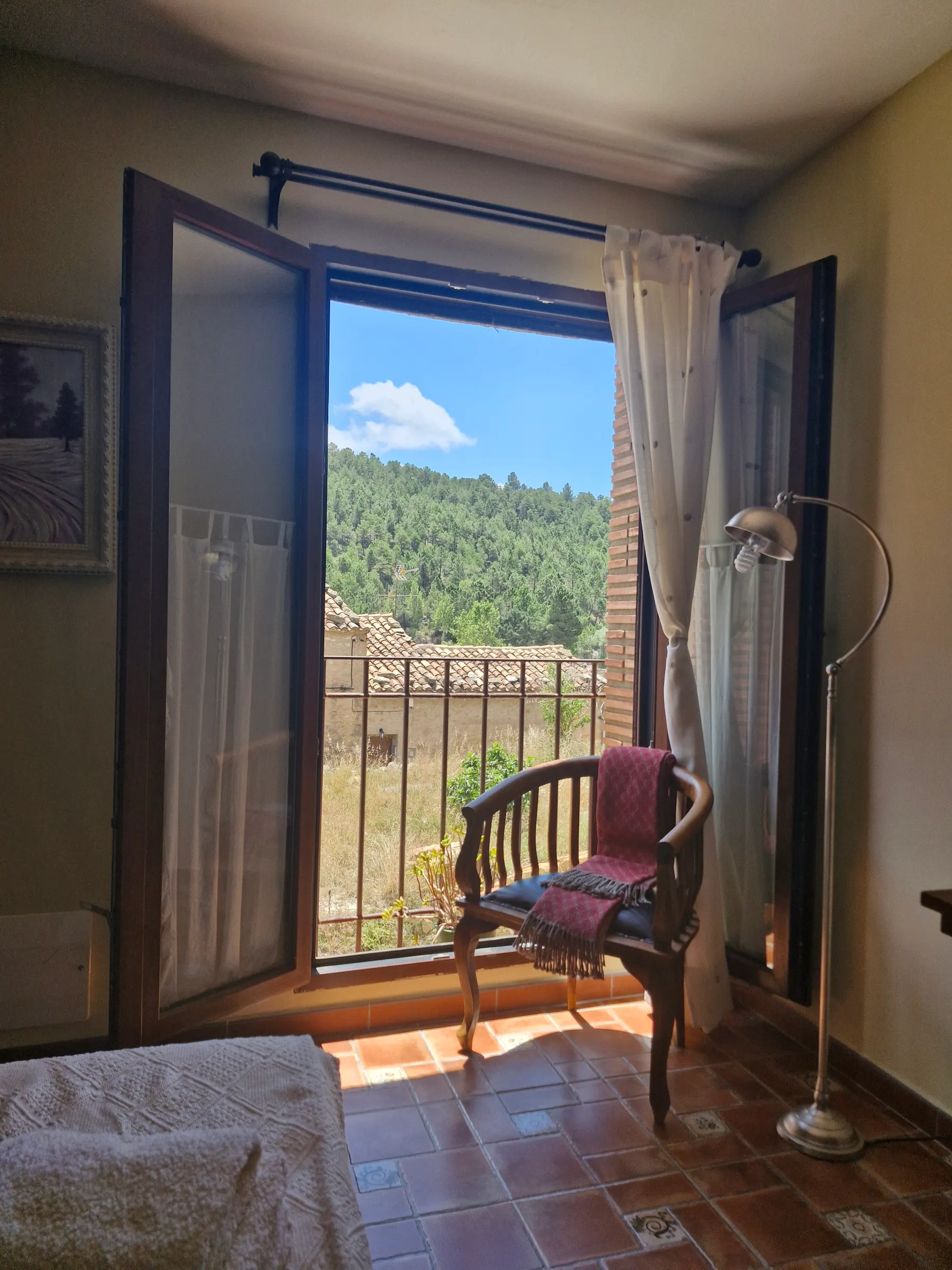 Puerta de balcón abierta de El Mirador con vistas al campo y la sierra