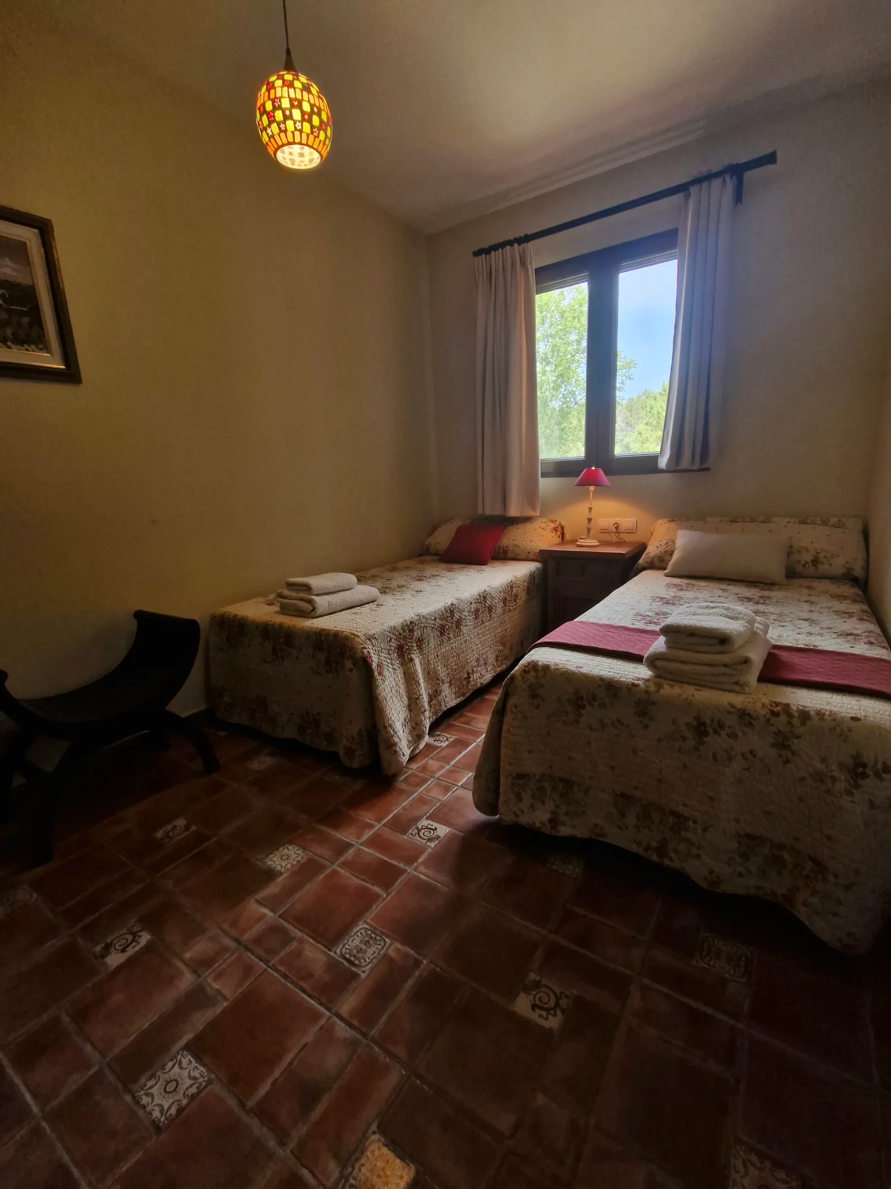 Dormitorio de El Mirador con dos camas individuales junto a la ventana