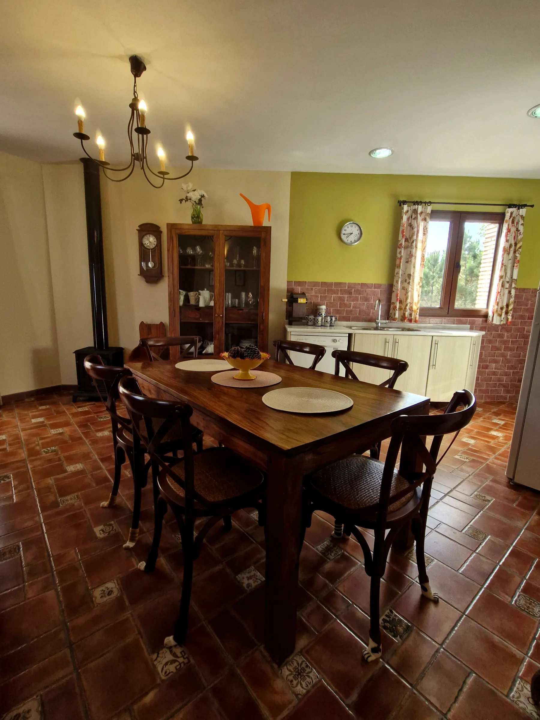 Comedor de El Mirador con mesa de madera, sillas y lámpara de araña